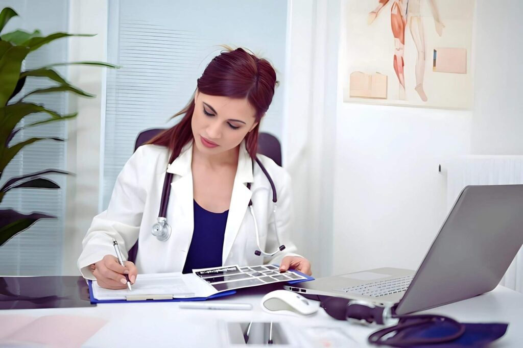 Female doctor reviewing medical records at desk in a clinical office